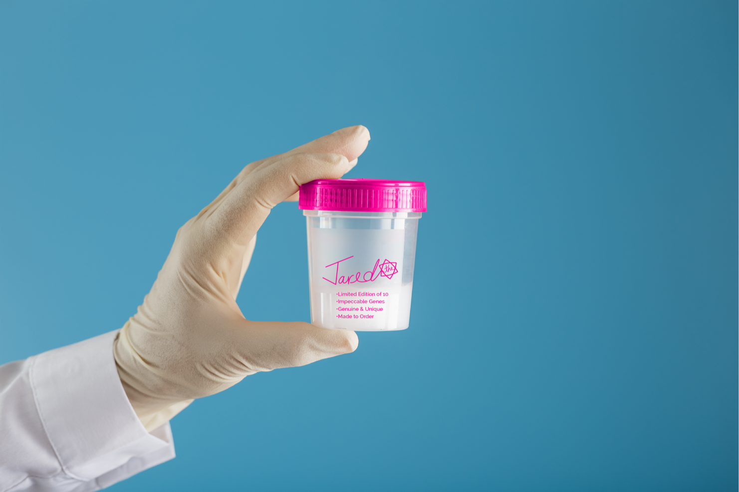 A gloved hand holds a specimen cup labeled Jared beside a small Star of David against a blue background.